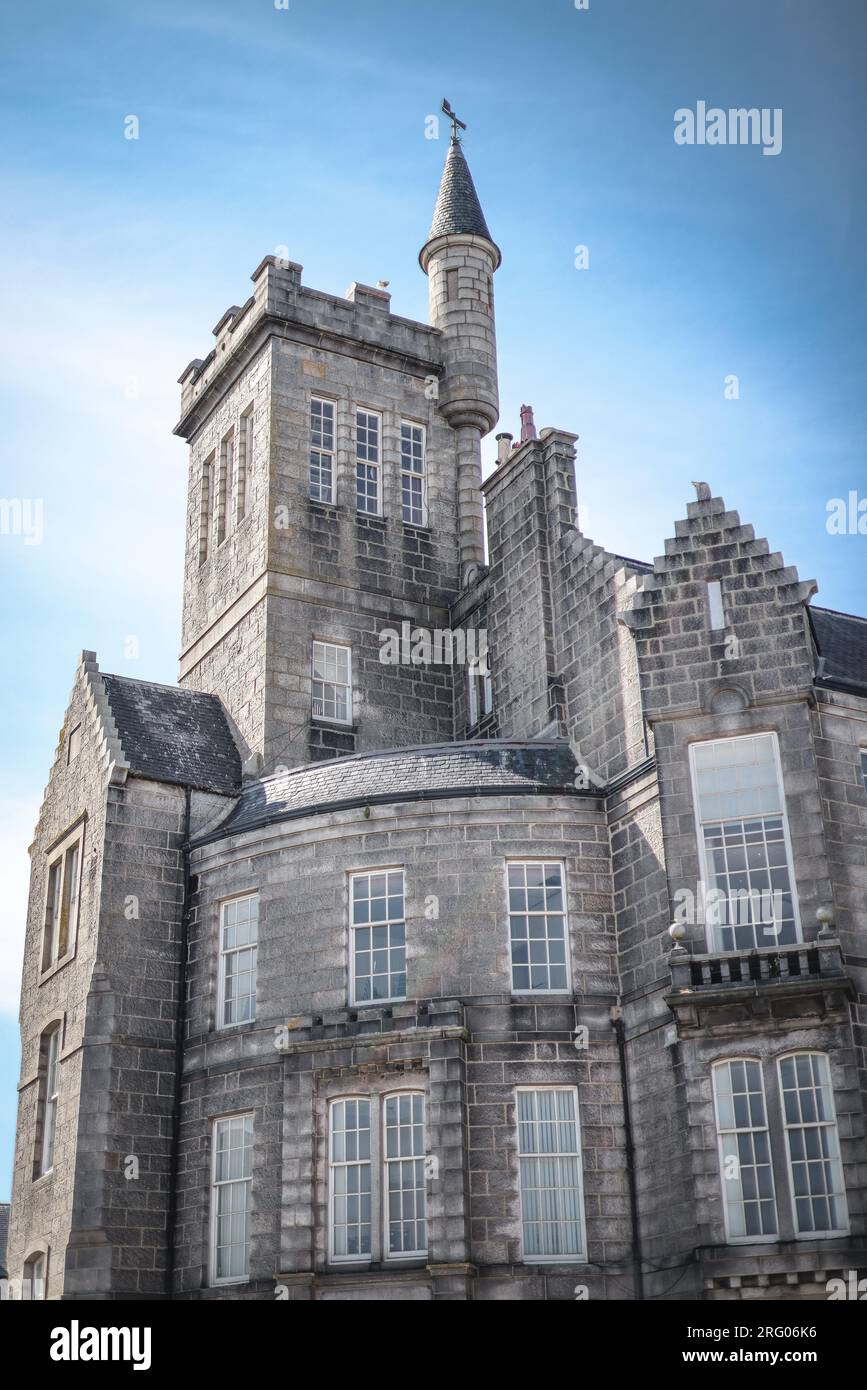 La Dalrymple Hall a Fraserburgh, nel nord-est della Scozia, in una giornata di sole. L'edificio simile a un castello, in granito grigio, è adagiato su un cielo blu. Foto Stock