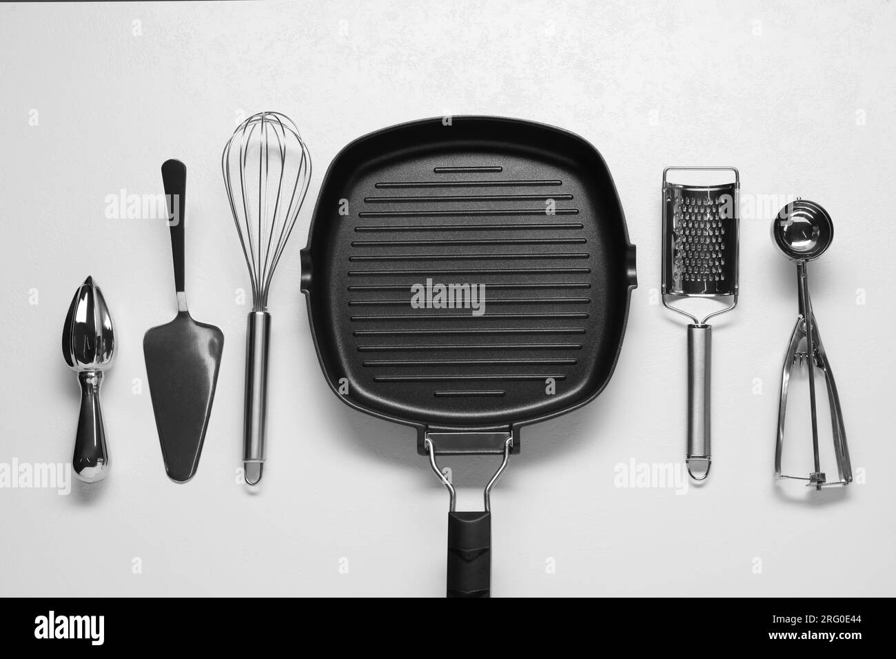 Set di diversi utensili da cucina su tavolo bianco, piatto Foto Stock