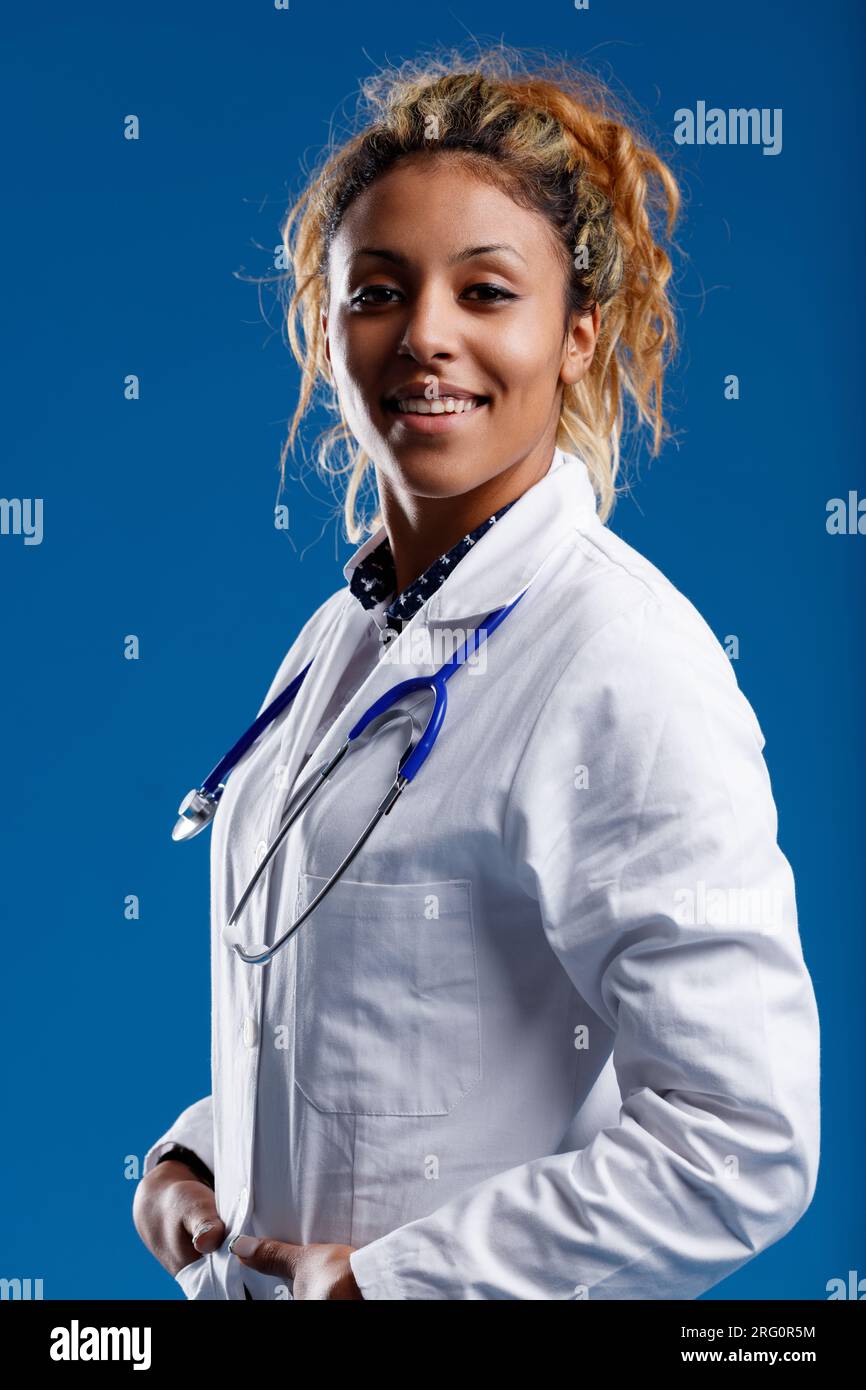 Medico con la pelle marrone, eccelle in biologia e fisiologia, offre supporto al paziente. Vede i pazienti come persone, non come corpi. Rassicurante in coa bianco Foto Stock
