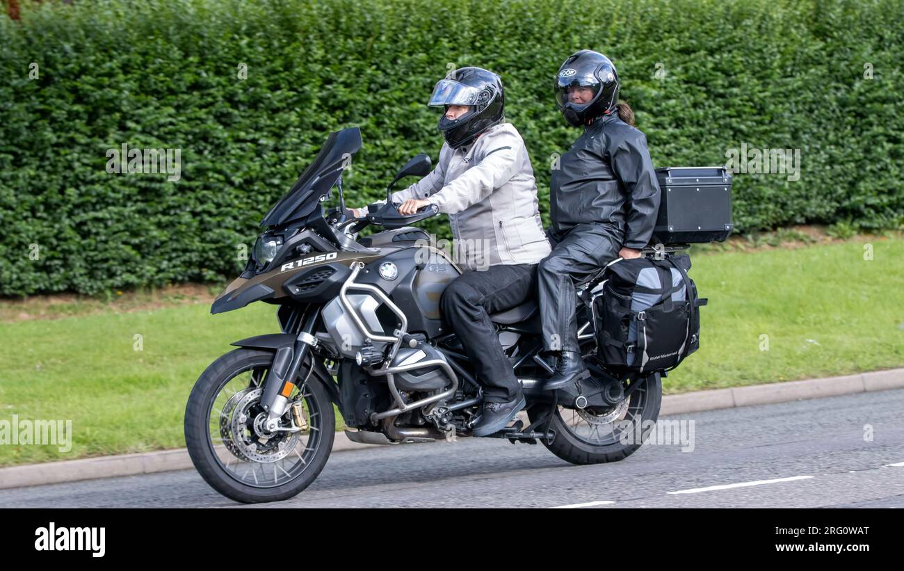 Whittlebury, Northants., UK - 6 agosto 2023. Turisti spagnoli in sella a una BMW R 1250 GS attraverso un villaggio inglese. Foto Stock