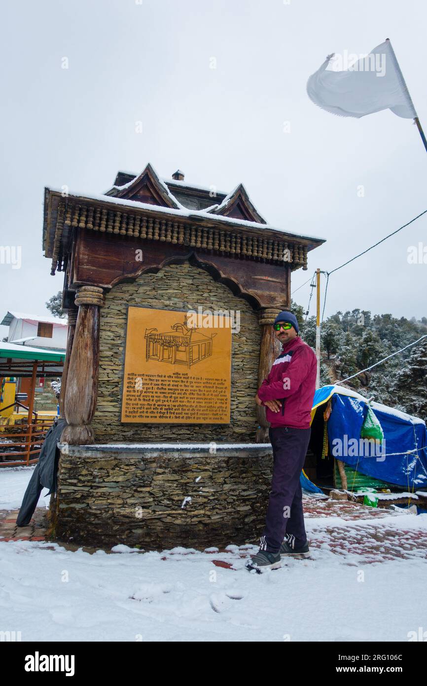 14 ottobre 2022, Uttarakhand India. Posa turistica del monumento del tempio Kartik Swami tra la neve invernale a Rudraprayag, Uttarakhand, India. Bellezza paesaggistica Foto Stock