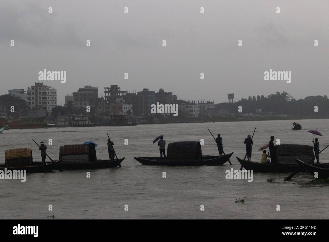 Narayanganj, Dacca, Bangladesh. 7 agosto 2023. I residenti attraversano il fiume Shitalakhya con barche di legno a Narayanganj, Bangladesh, in un giorno di pioggia. La stagione dei monsoni porta forti piogge nel paese. In effetti, circa il 80% delle piogge annuali del Bangladesh si verificano da giugno a ottobre e, alla fine della stagione dei monsoni, quasi un terzo del paese è sott'acqua. Il Bangladesh è un paese molto umido, che riceve in media circa 2.200 millimetri (mm) di precipitazioni all'anno. (Immagine di credito: © Joy Saha/ZUMA Press Wire) SOLO USO EDITORIALE! Non per USO commerciale! Foto Stock