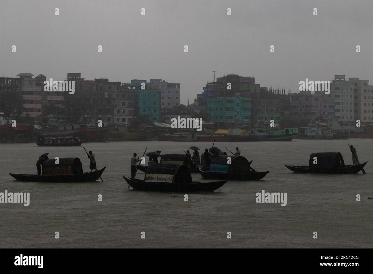 Narayanganj, Dacca, Bangladesh. 7 agosto 2023. I residenti attraversano il fiume Shitalakhya con barche di legno a Narayanganj, Bangladesh, in un giorno di pioggia. La stagione dei monsoni porta forti piogge nel paese. In effetti, circa il 80% delle piogge annuali del Bangladesh si verificano da giugno a ottobre e, alla fine della stagione dei monsoni, quasi un terzo del paese è sott'acqua. Il Bangladesh è un paese molto umido, che riceve in media circa 2.200 millimetri (mm) di precipitazioni all'anno. (Immagine di credito: © Joy Saha/ZUMA Press Wire) SOLO USO EDITORIALE! Non per USO commerciale! Foto Stock