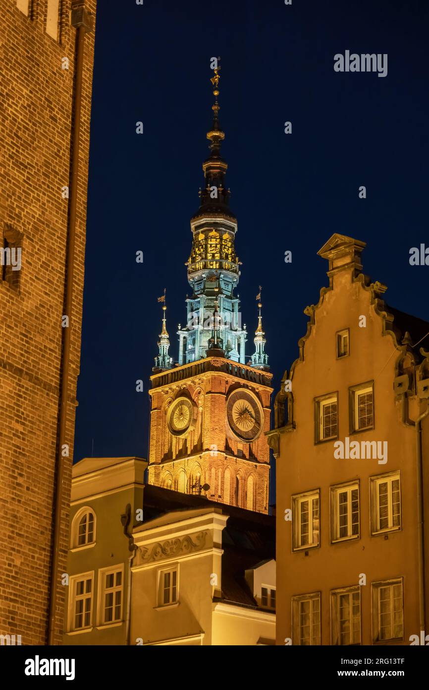 La torre principale del municipio e le case storiche di notte nella città di Danzica, Polonia. Architettura gotica e rinascimentale nella città vecchia. Foto Stock