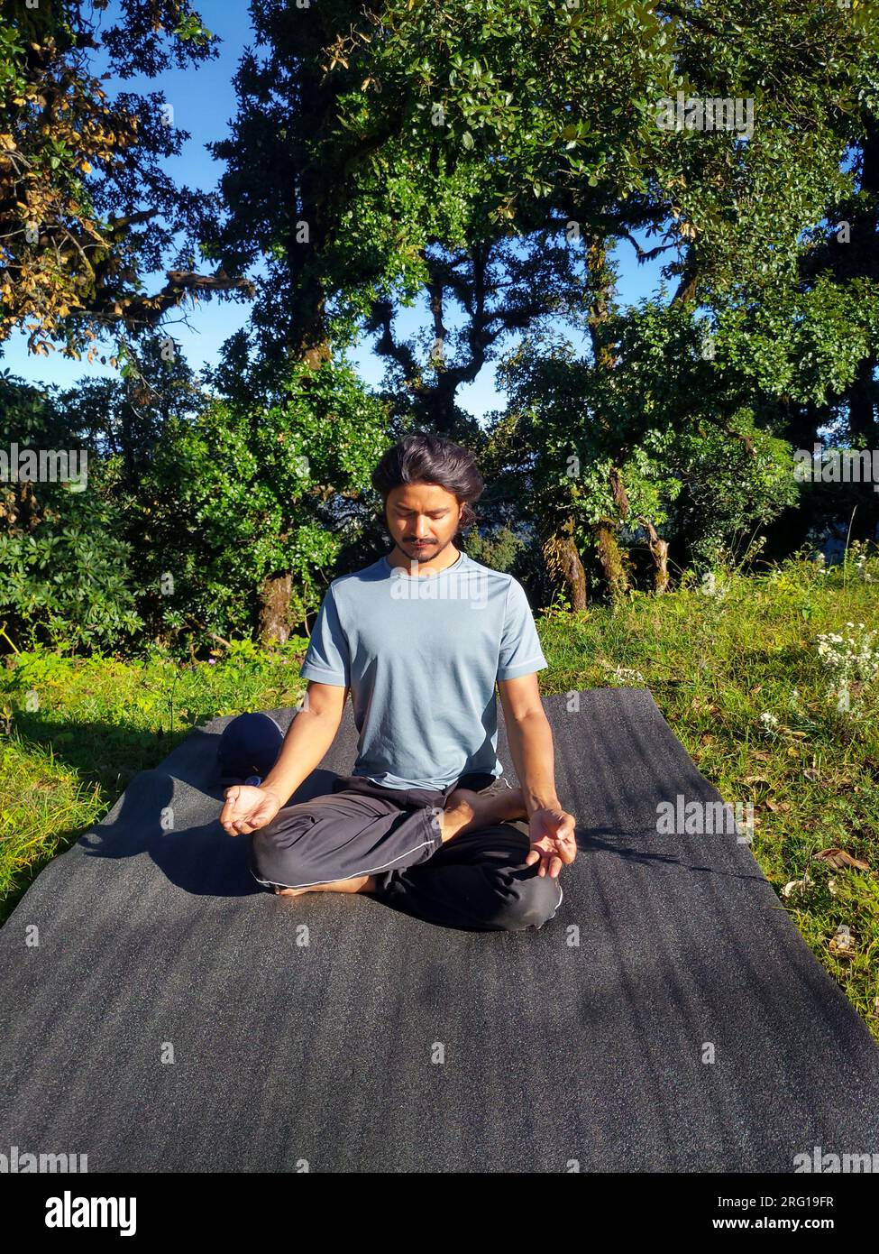 14 ottobre 2022, Uttarakhand India. Momenti sereni: Un uomo medita tra le bellezze naturali durante un viaggio in campeggio sull'Himalaya a Uttarakhand. Trova pe Foto Stock