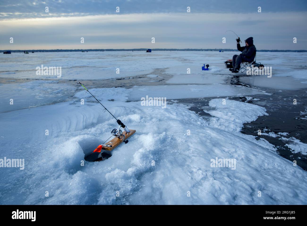 Pesca sul ghiaccio del lago ghiacciato Foto Stock