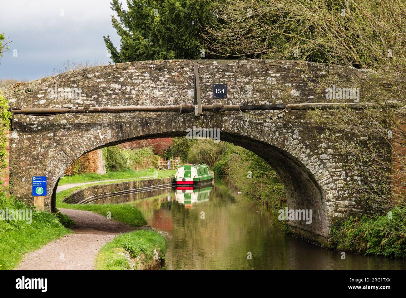 Ammira il vecchio ponte 154 fino alla barca stretta ormeggiata da un sentiero sul Monmouthshire e sul Brecon Canal. Pencelli, Brecon, Powys, Galles, Regno Unito, la Gran Bretagna Foto Stock