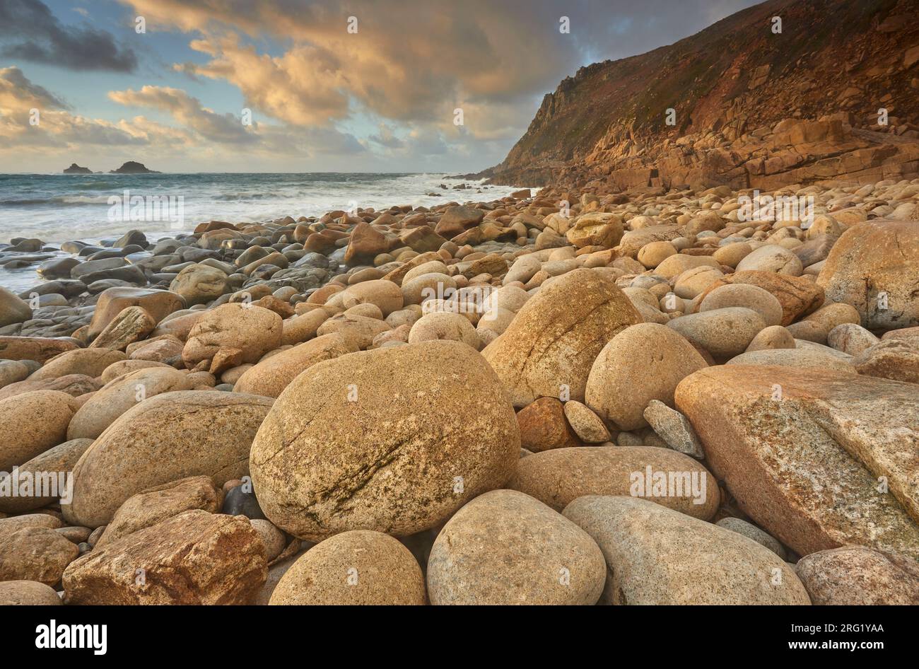 Una sponda ricoperta di massi di granito in una baia sulla costa atlantica dell’estrema ovest della Cornovaglia; Porth Nanven, Cot Valley, St Just, Cornovaglia, REGNO UNITO Foto Stock