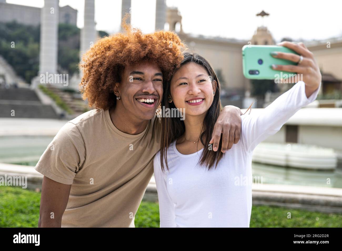 Una giovane coppia sorridente che scatta un selfie con il telefono all'aperto. Coppia allegra sorridente e scattante una foto all'aperto. Foto Stock