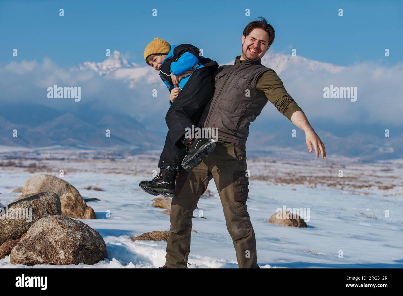 Buon padre e bambino che si divertono in montagna durante la stagione invernale Foto Stock