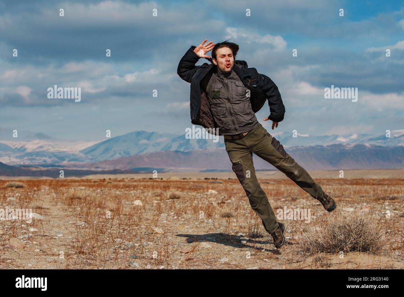Uomo che salta sullo sfondo delle montagne, in Kirghizistan Foto Stock
