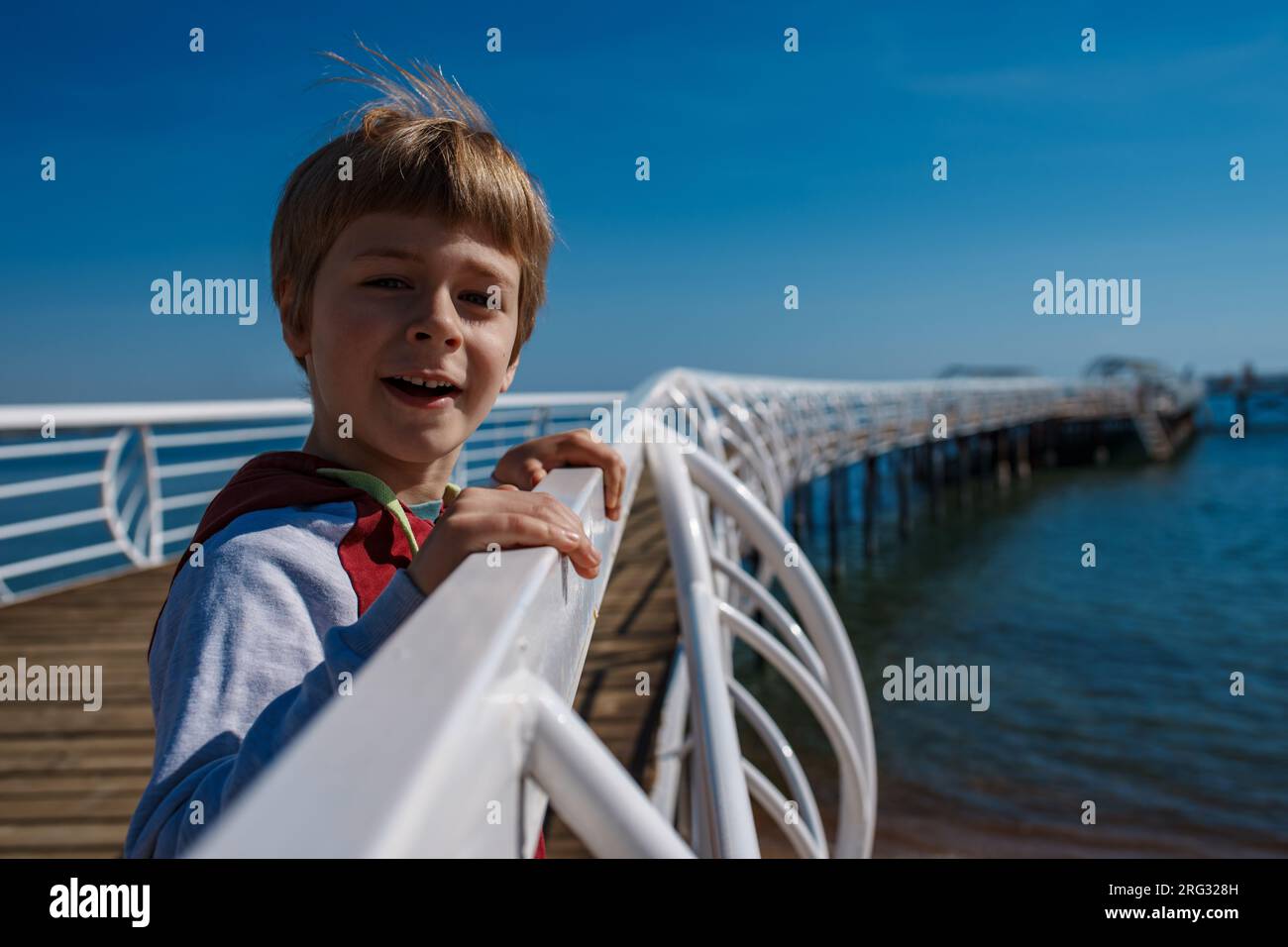 Ritratto di un ragazzo felice su un molo Foto Stock