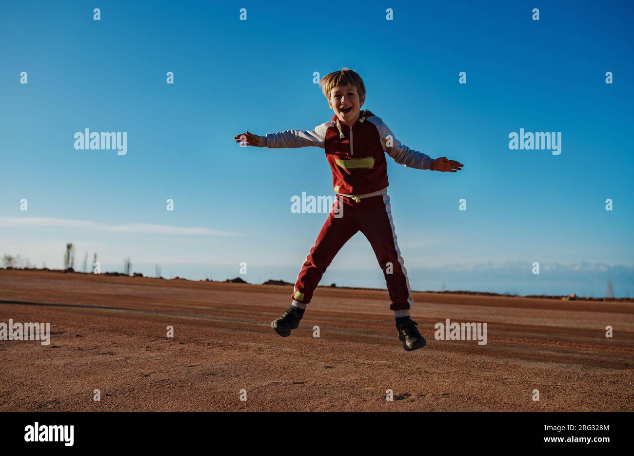 Happy Boy salta su sfondo blu Foto Stock