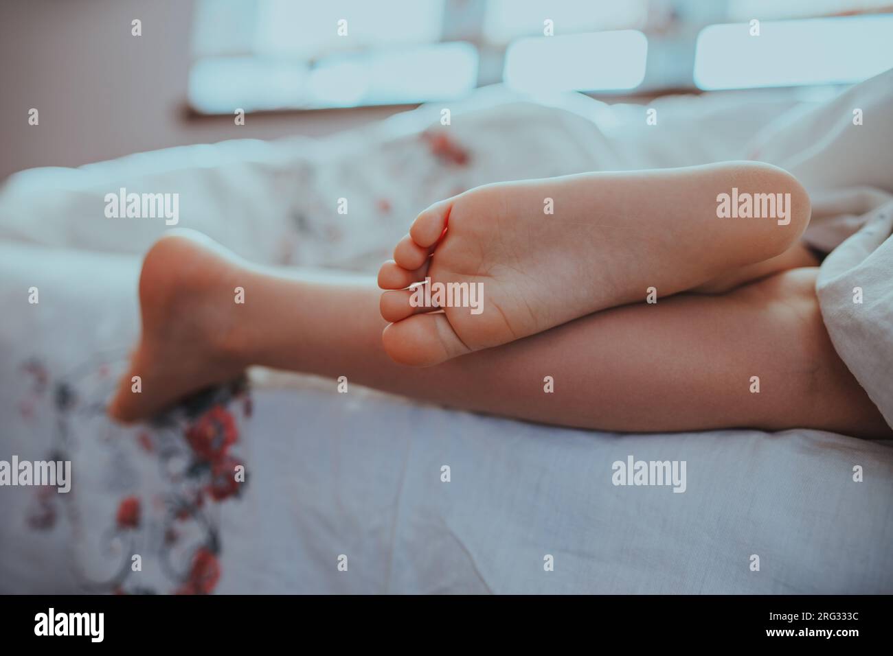 I piedi di un bambino che dorme sul letto Foto Stock