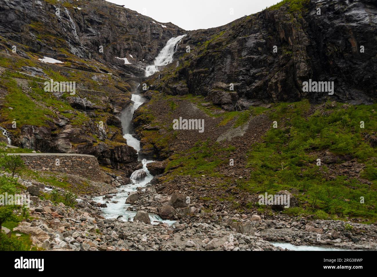 La cascata di Stigfossen si surge oltre gli affioramenti rocciosi vicino a Trollstigen Road. Trollstigen, Rauma, Norvegia. Foto Stock
