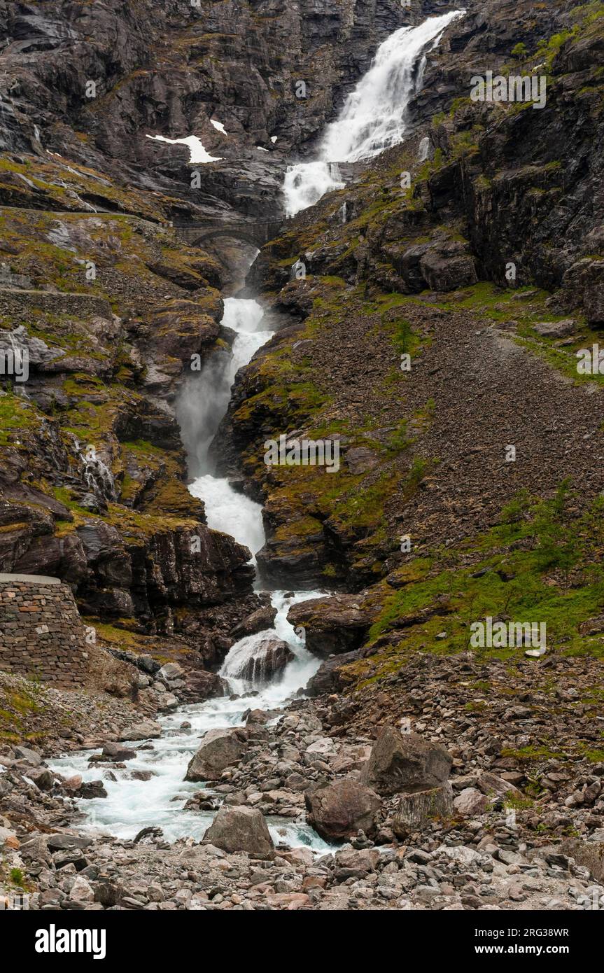 La cascata di Stigfossen si surge oltre gli affioramenti rocciosi vicino a Trollstigen Road. Trollstigen, Rauma, Norvegia. Foto Stock