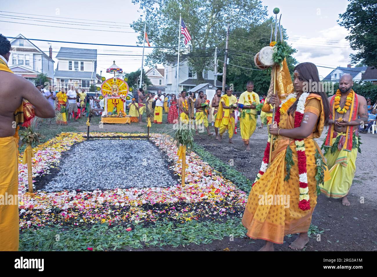 Prima del rituale indù di Thimithee, i devoti marciano intorno ai carboni caldi mentre cantano. In Giamaica, Queens, New York. Foto Stock