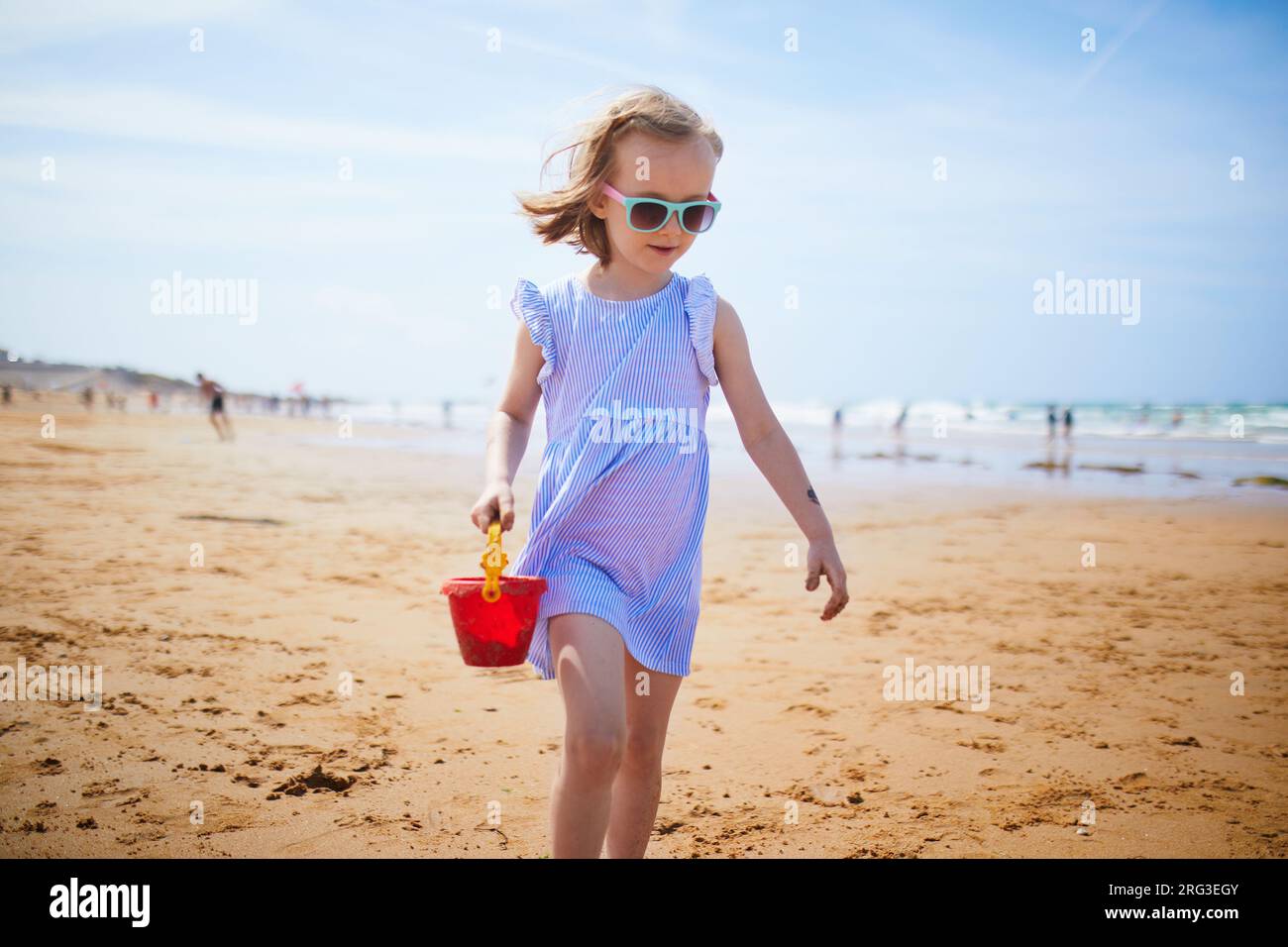 Adorabile preshooler che gioca sulla spiaggia di sabbia della costa atlantica della Bretagna, in Francia. Bambini piccoli che si divertono in vacanza al mare o all'oceano. Travellin Foto Stock