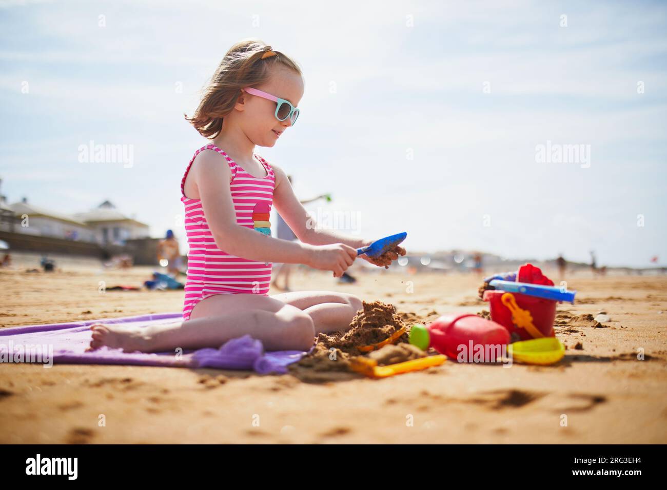 Adorabile preshooler che gioca sulla spiaggia di sabbia della costa atlantica della Bretagna, in Francia. Bambini piccoli che si divertono in vacanza al mare o all'oceano. Travellin Foto Stock