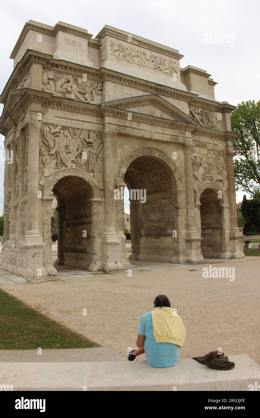 Arco trionfale d'arancia con un solo uomo seduto e rilassante di fronte Foto Stock