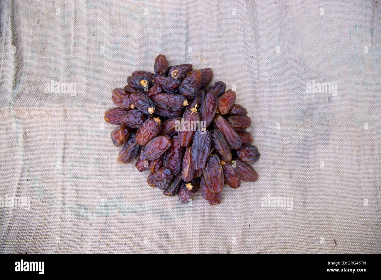 Alcuni deliziosi frutti datteri sul tessuto di fibra di iuta marrone da mangiare durante il digiuno Ramadan Karim Foto Stock