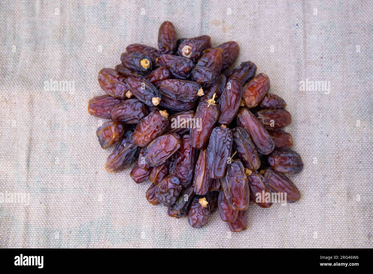 Alcuni deliziosi frutti datteri sul tessuto di fibra di iuta marrone da mangiare durante il digiuno Ramadan Karim Foto Stock