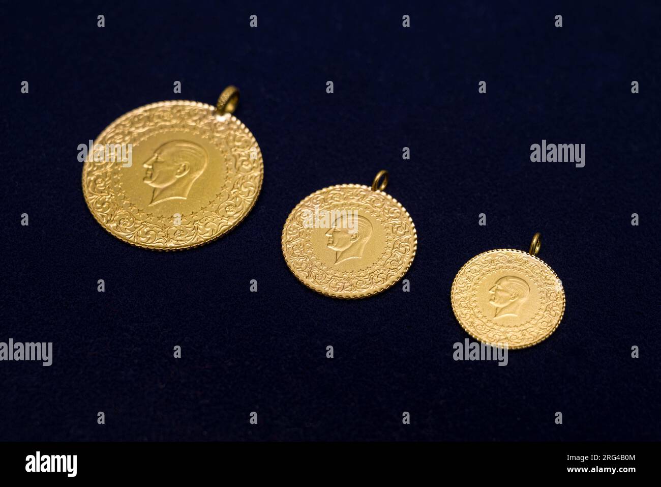 Monete d'oro turche complete, metà e un quarto affiancate su sfondo blu scuro Foto Stock