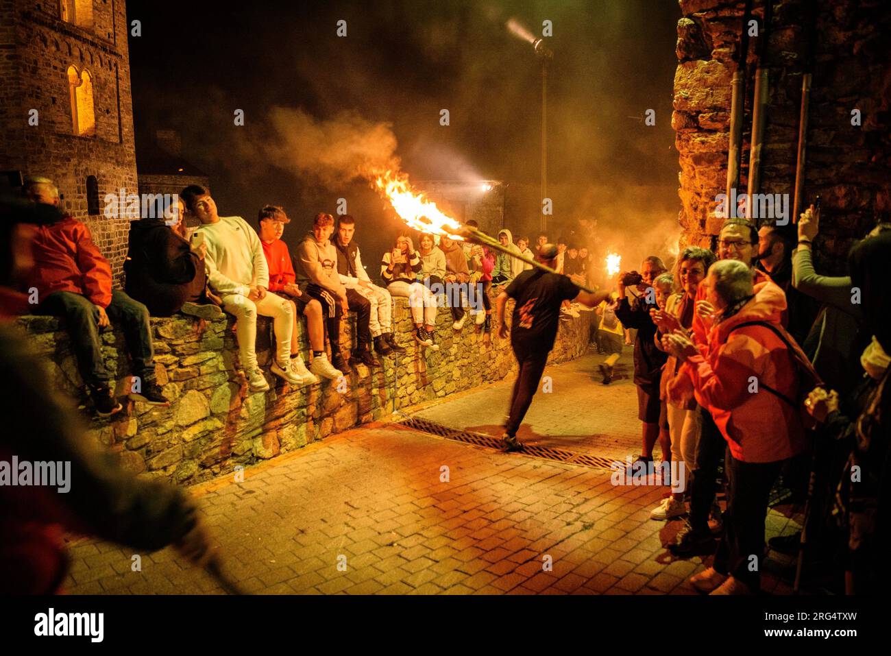 Partecipanti alle Falles che corrono all'ingresso del villaggio di Durro, nella valle di Boí (Ribagorca, Lleida, Catalogna, Spagna, Pirenei) Foto Stock