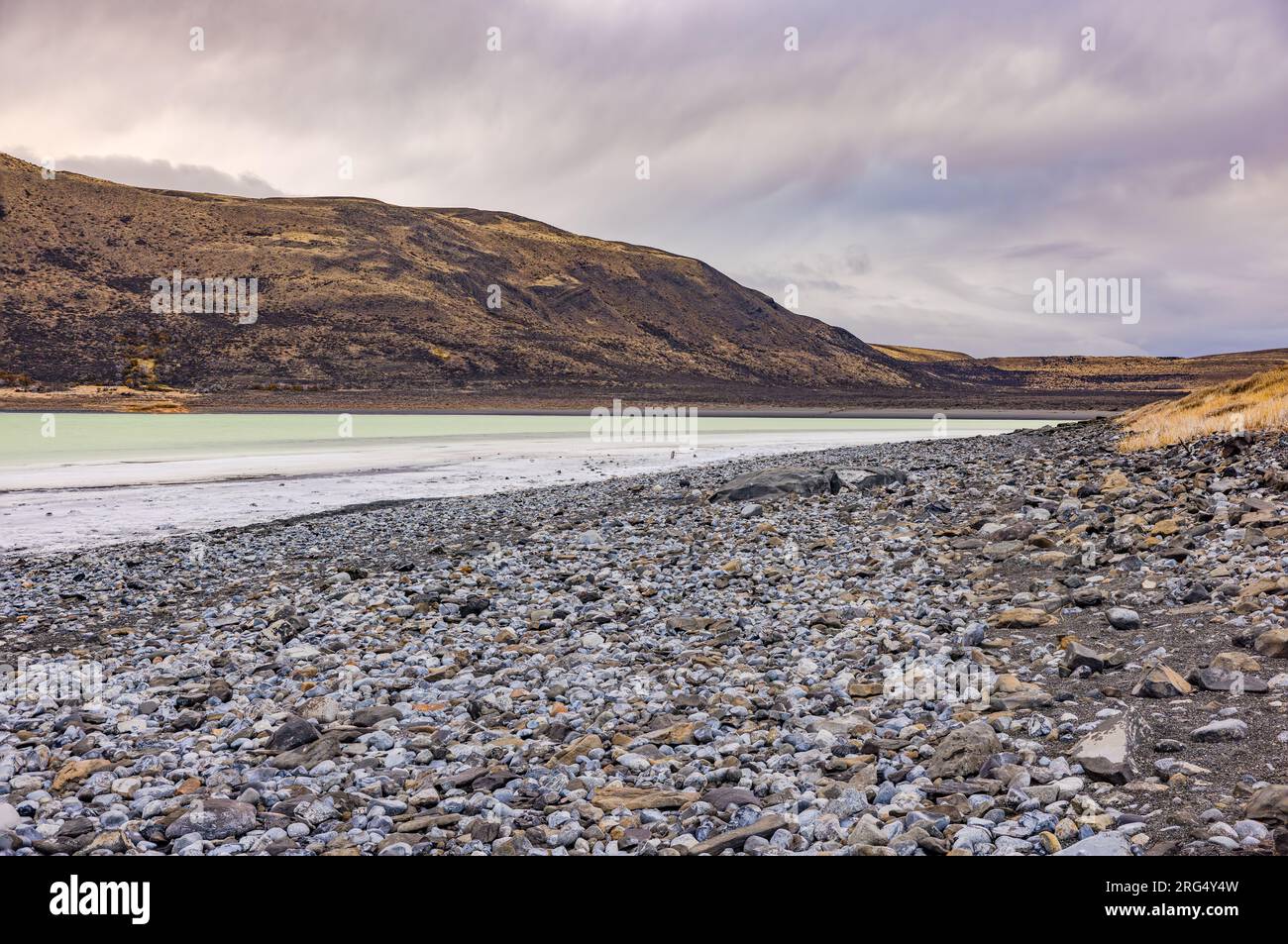 Spiaggia di ciottoli con sale nelle turchesi Laguna Amarga, Parco Nazionale Torres del Paine, Cile, Patagonia, Sud America Foto Stock