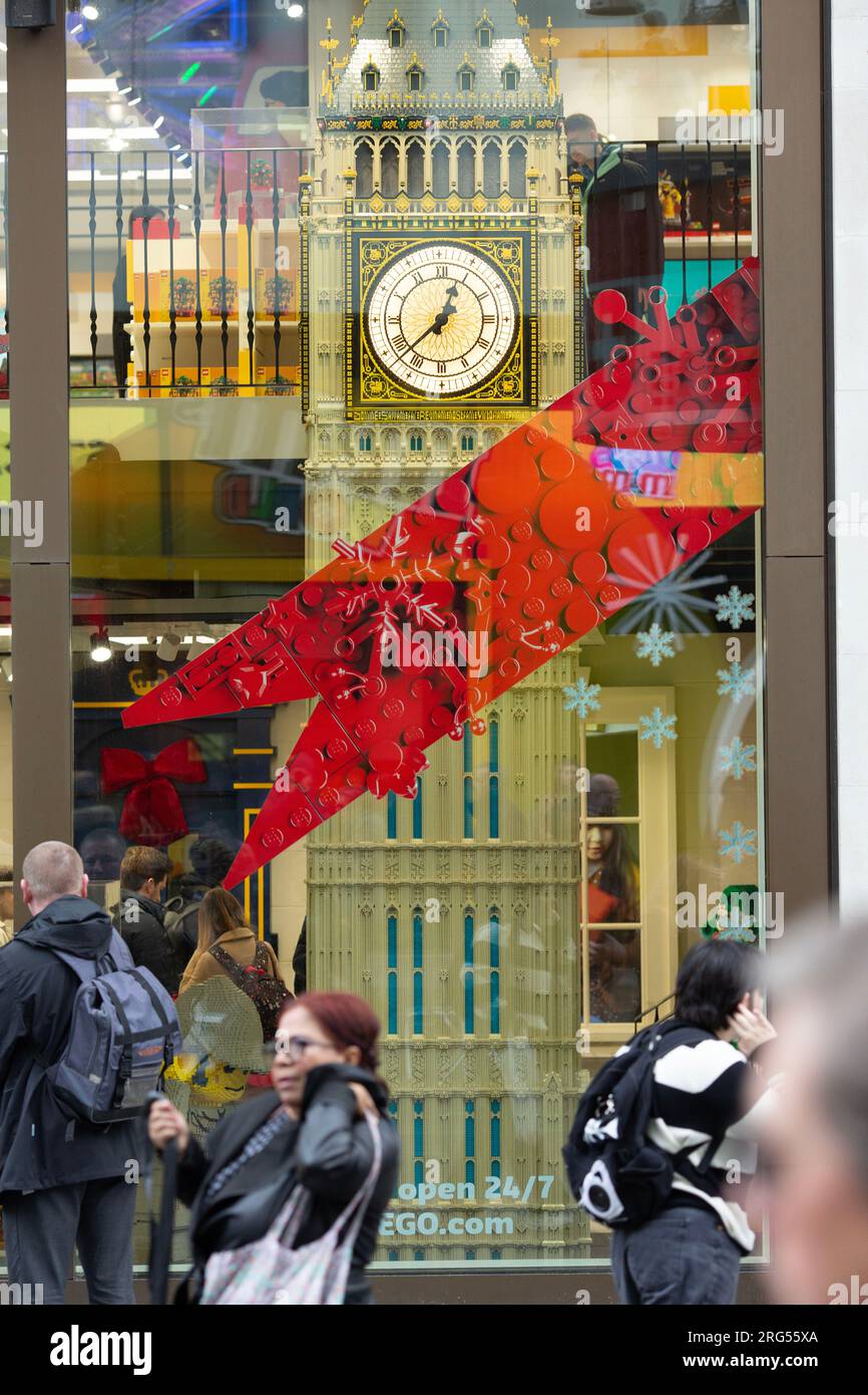 La gente passa davanti a un modello della Elizabeth Tower, che ospita il Big Ben, esposto in una vetrina nel centro di Londra, il giorno di Capodanno. Foto Stock