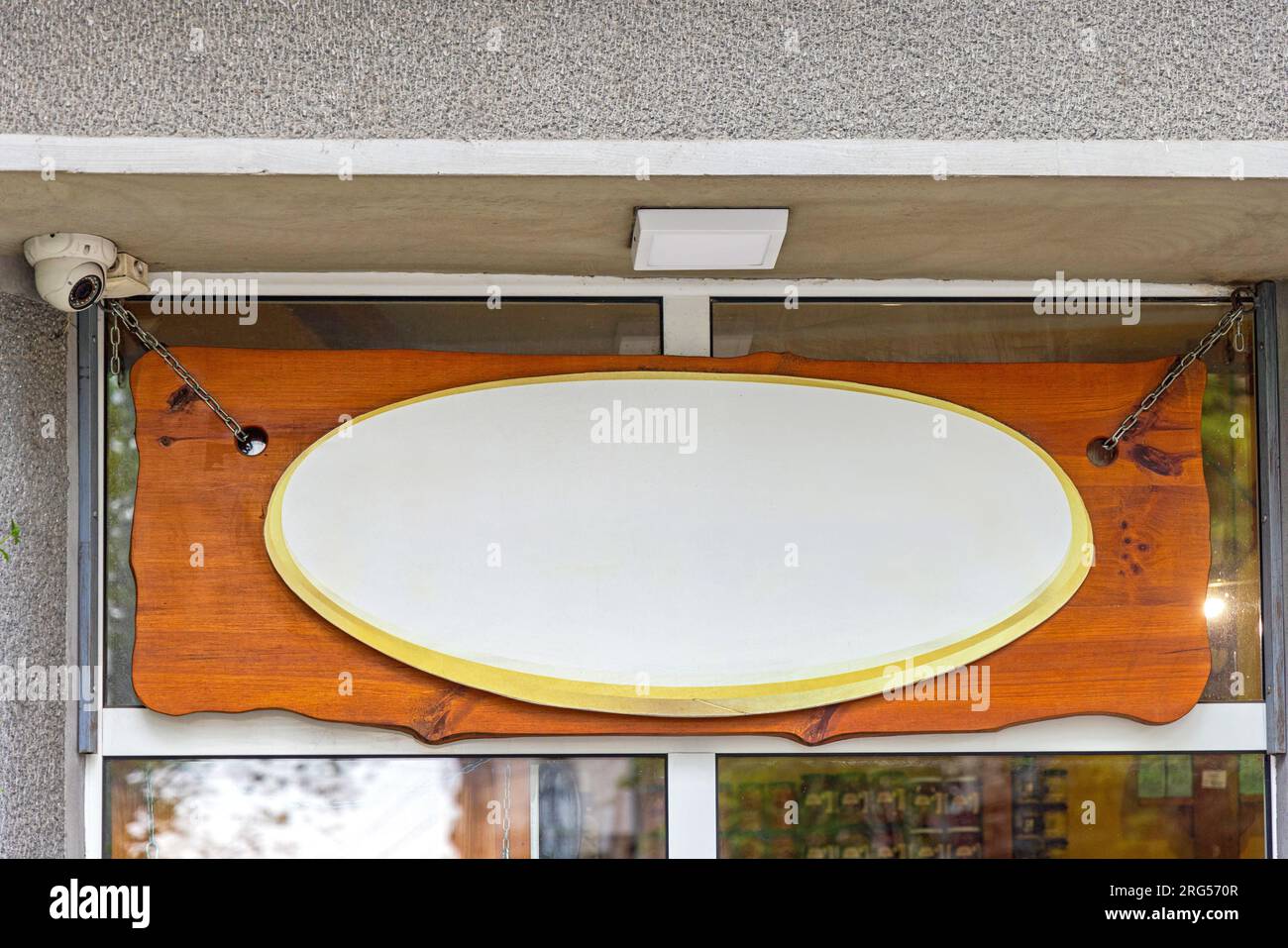 Spazio per la copia dei segni ovali sul pannello frontale del negozio Plank in legno sospeso Foto Stock