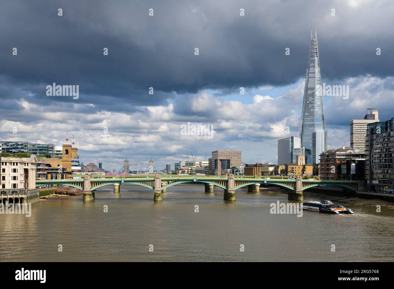 Londra, Regno Unito - 28 luglio 2023; vista a est lungo il Tamigi a Londra del Southwark Bridge e dello Shard nel giorno tempestoso Foto Stock