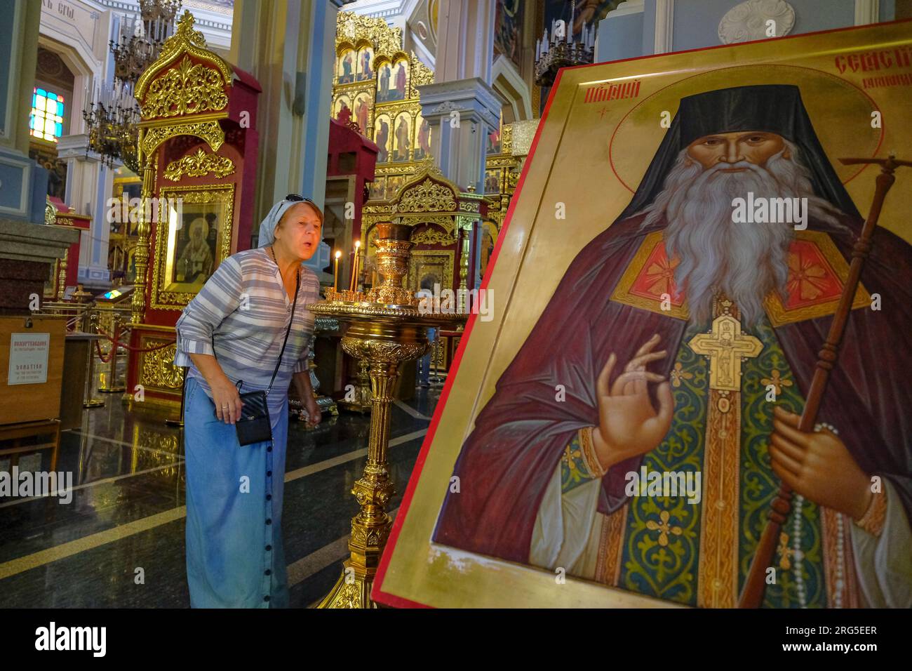 Almaty, Kazakistan - 6 agosto 2023: Una donna che soffia le candele nella cattedrale dell'Ascensione ad Almaty, Kazakistan. Foto Stock