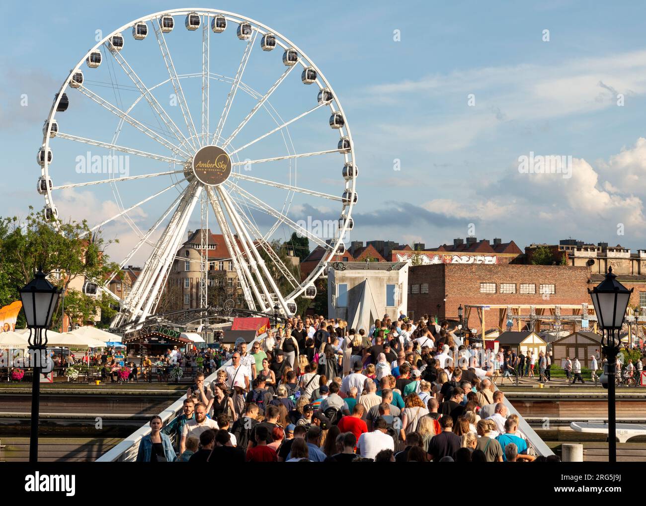 Folla di persone sul ponte Wartka che attraversa il fiume Motlawa presso il cielo Ambra o la ruota panoramica AmberSky nella città vecchia di Danzica, Polonia, Europa, UE Foto Stock