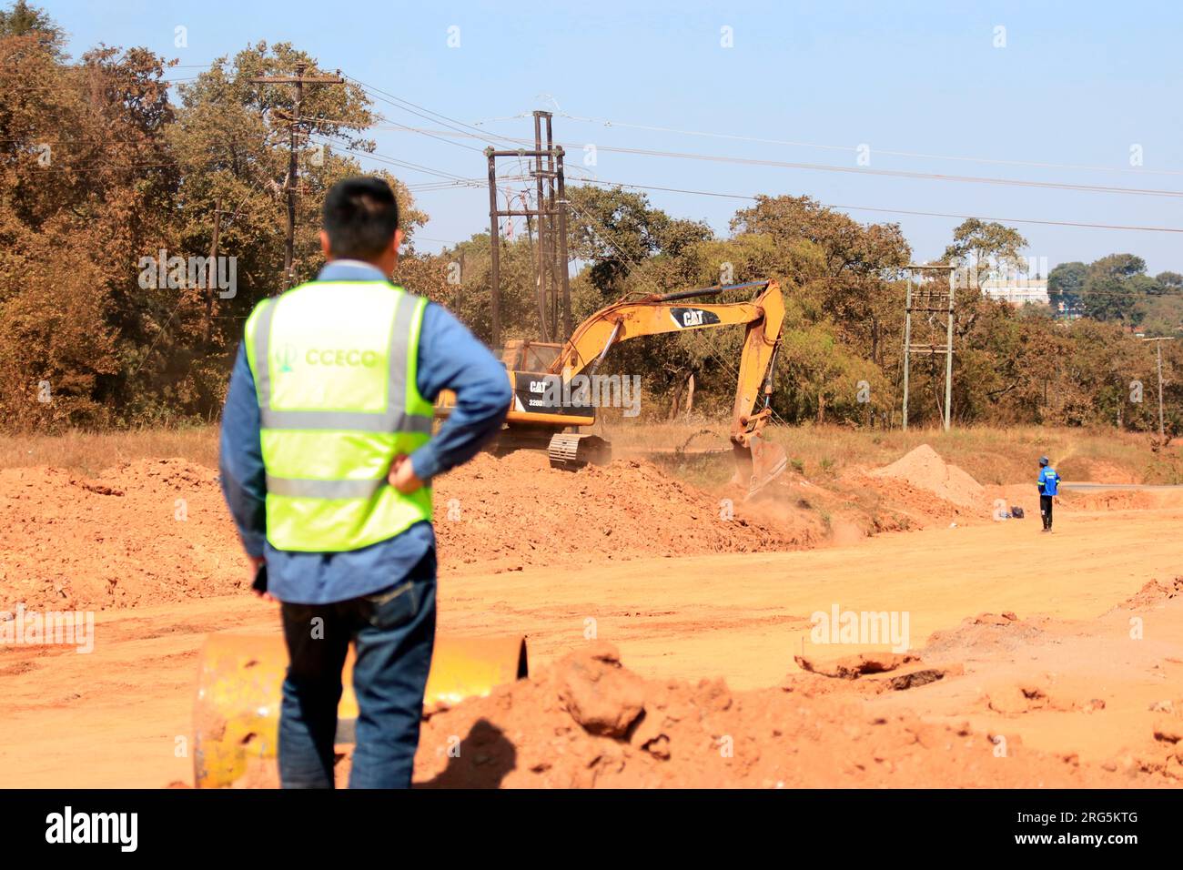 Si vede un uomo che supervisiona i lavori di costruzione che si svolgono lungo Kenyatta Drive, dove la strada viene ampliata per ospitare più traffico a Lilongwe, Malawi. Foto Stock