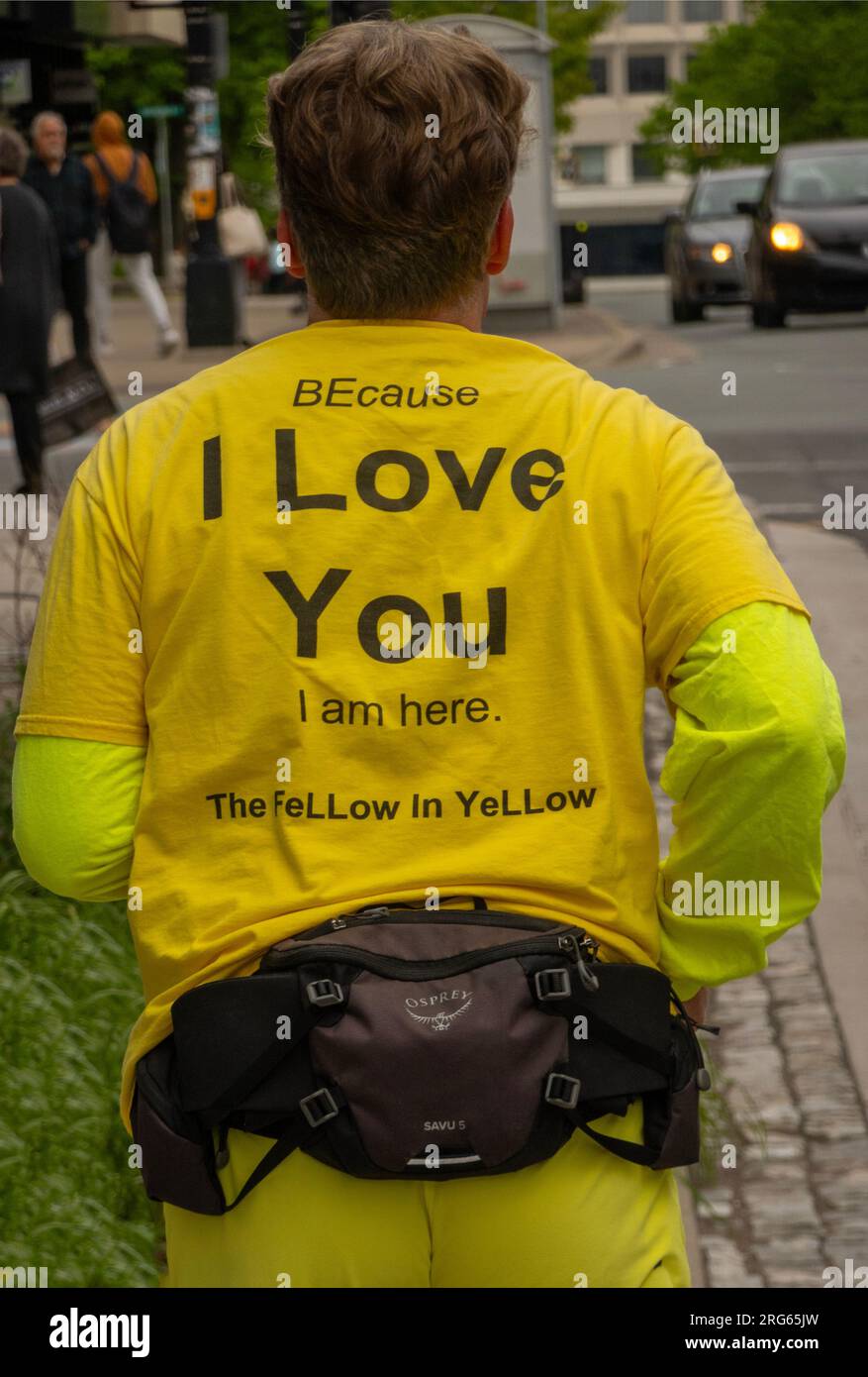 Perché ti amo, sono qui. Il tizio in giallo in una strada a Halifax, nuova Scozia, Canada Foto Stock