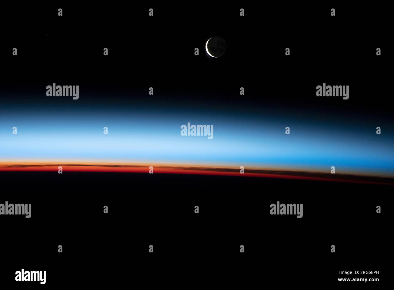 L'orizzonte terrestre e una sezione trasversale di strati atmosferici, con sopra una luna crescente cerata. Foto Stock