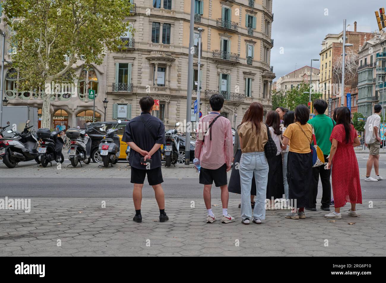 04.08.2023. Barcellona, ​​​​Spain, piccolo gruppo di turisti orientali nel centro del passeig de gracia che osserva la casa batllo Foto Stock