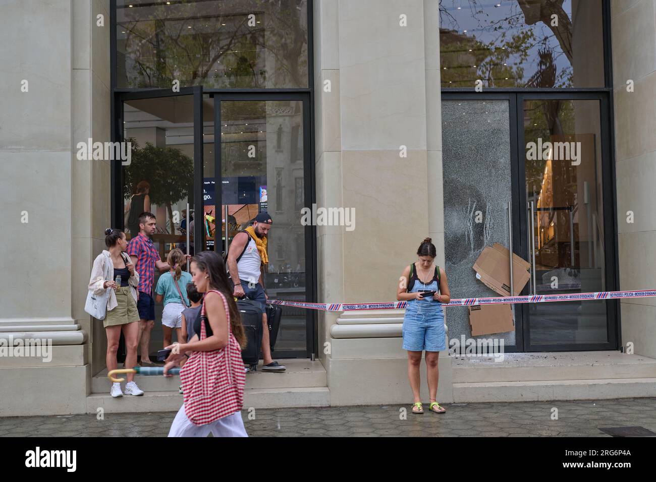 04.08.2023. Barcellona, ​​​​Spain, gente che lascia il negozio di plaza catalunya con un bicchiere rotto per tentato rapina Foto Stock