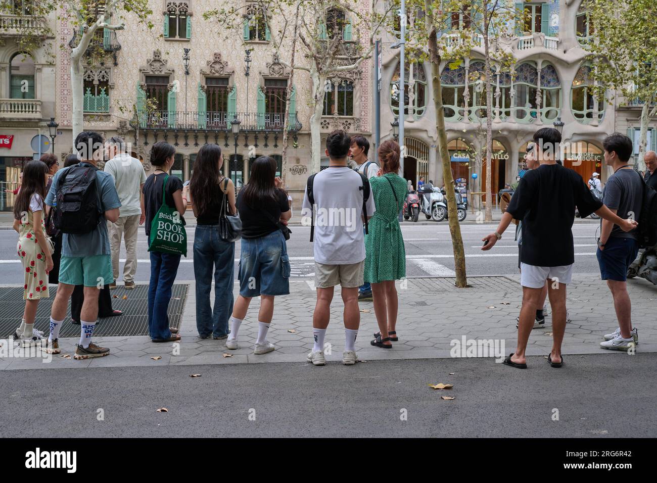 04.08.2023. Barcellona, ​​Spain, turisti orientali con una guida turistica di fronte alla Casa Batllo Foto Stock