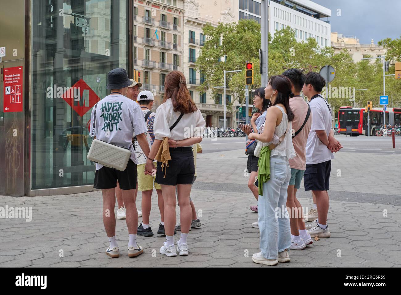 04.08.2023. Barcellona, ​​​​Spain, piccolo gruppo di turisti orientali in pieno passeig de gracia Foto Stock