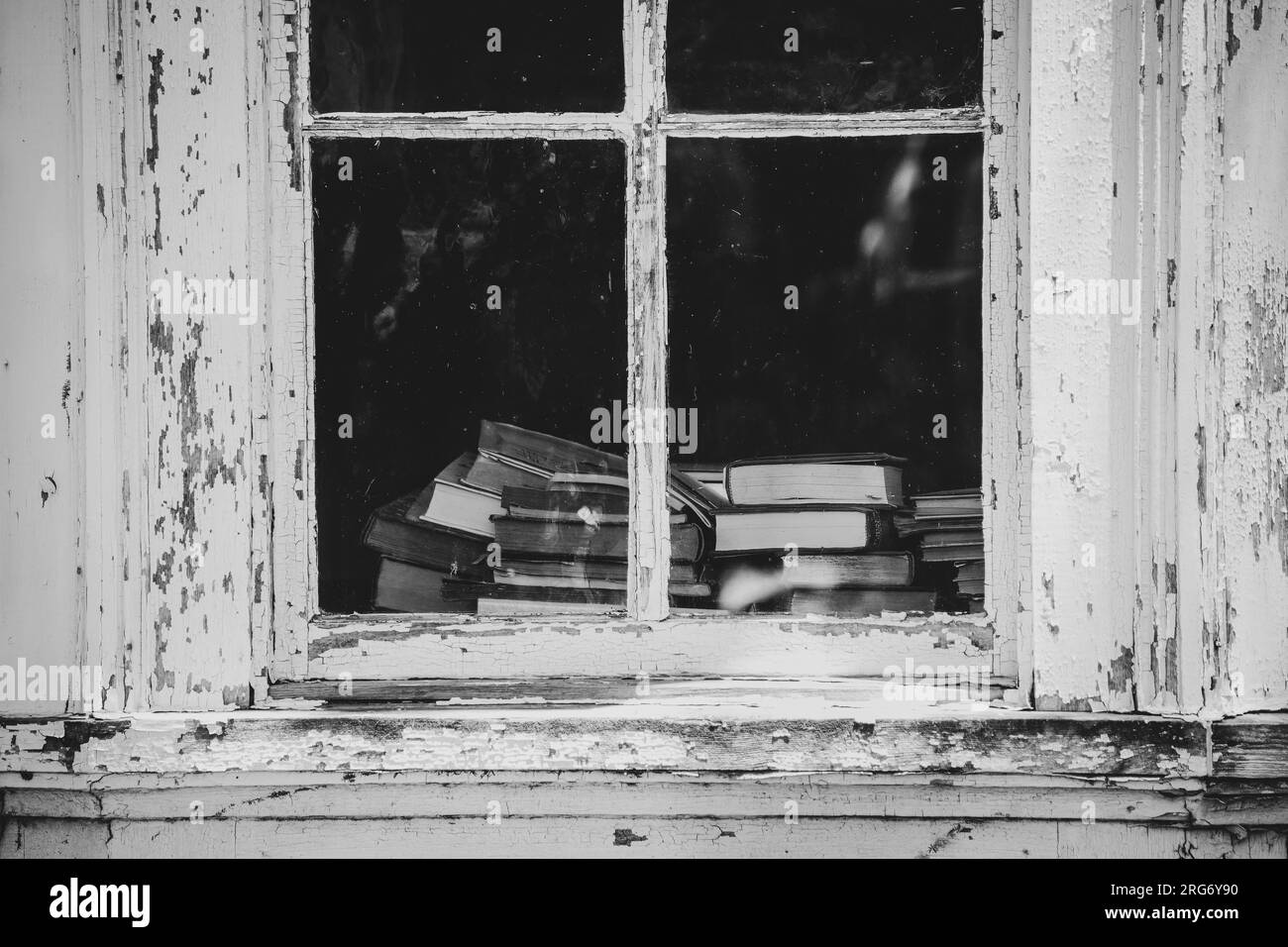 Pila di libri d'epoca visti dalla finestra nella vecchia casa Foto Stock