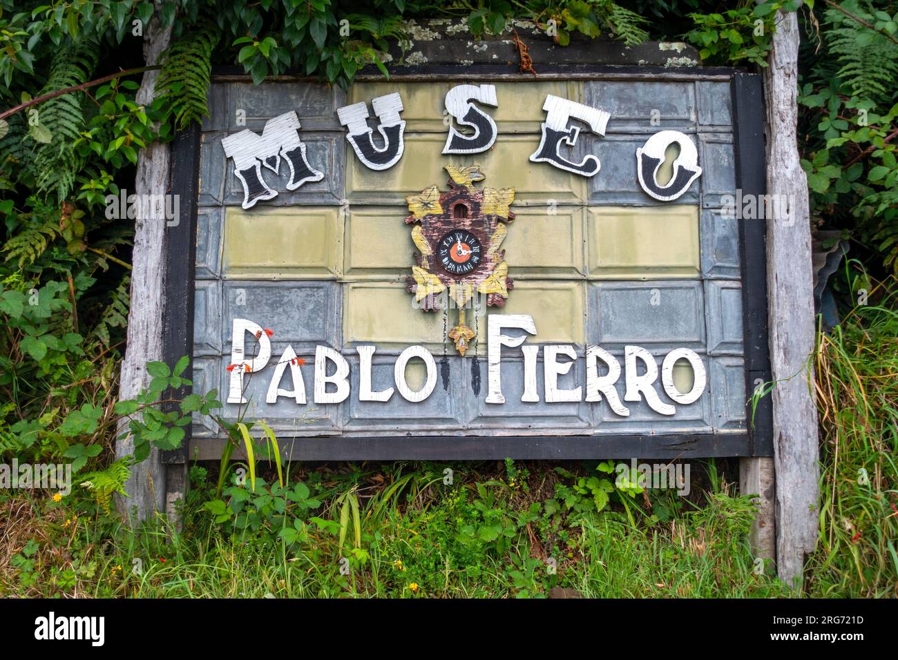 Tabella informativa d'ingresso insegna per il Museo Pablo Fierro con mix di Chilote e patrimonio culturale tedesco, sfondo lussureggiante di fogliame, Puerto Varas, Cile Foto Stock