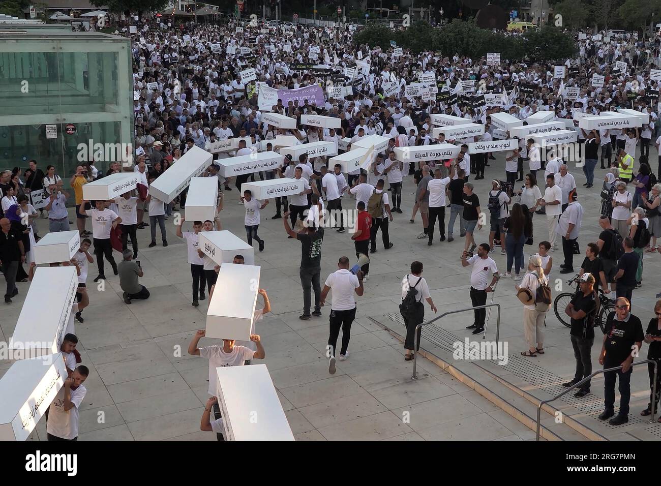 I manifestanti portano bare di cartone in memoria dei 141 arabi israeliani uccisi dall'inizio dell'anno, mentre marciano attraverso il centro della città durante una protesta tenuta dagli arabi israeliani contro ciò che affermano è l'inazione della polizia in mezzo al crescente crimine e violenza nelle comunità arabe il 6 agosto 2023 a Tel Aviv, in Israele. Foto Stock