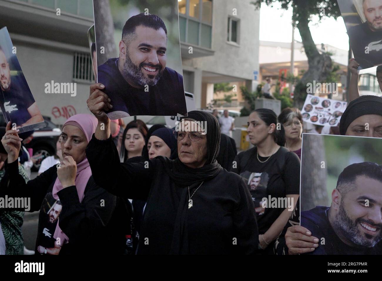 Gli arabi israeliani tengono fotografie dei loro parenti che hanno perso la vita in omicidi mentre marciano attraverso il centro della città durante una protesta contro ciò che sostengono sia l'inazione della polizia in mezzo al crescente crimine e alla violenza nelle comunità arabe il 6 agosto 2023 a Tel Aviv, in Israele. Foto Stock