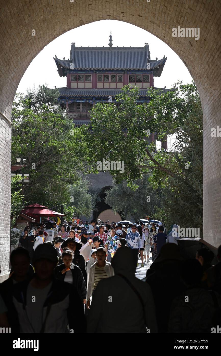 Jiayuguan, provincia cinese del Gansu. 7 agosto 2023. I turisti visitano il passo Jiayu nella città di Jiayuguan, provincia del Gansu della Cina nord-occidentale, 7 agosto 2023. Il passo Jiayu, una famosa parte della grande Muraglia costruita durante la Dinastia Ming (1368-1644), ha attirato un numero crescente di visitatori durante la stagione turistica estiva, con oltre 30.000 visitatori al giorno in picco. Crediti: Fan Peishen/Xinhua/Alamy Live News Foto Stock