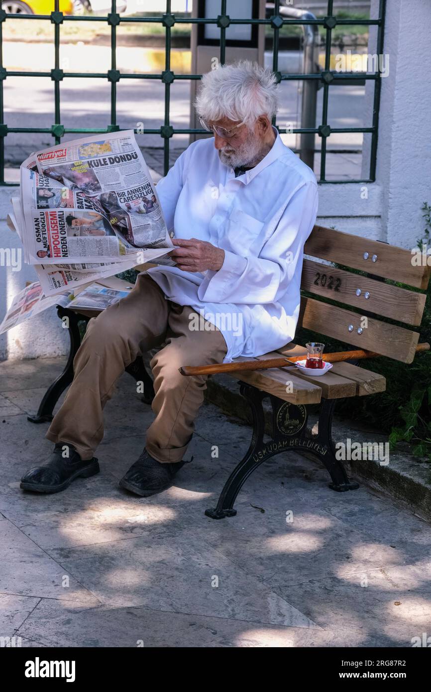 Istanbul, Turchia, Türkiye. Uskudar Man beve tè e legge il giornale. Foto Stock