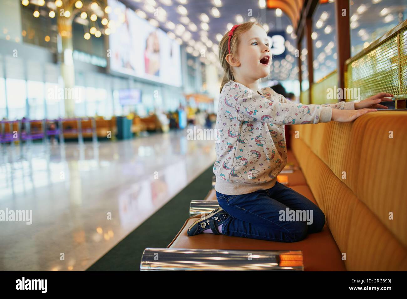 Adorabile bambina in età prescolare che si diverte all'aeroporto internazionale. Viaggia con il concetto dei bambini Foto Stock