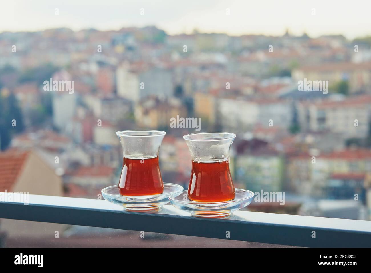 Due bicchieri turchi a forma di tulipano riempito di tè nero caldo con vista sui tetti del distretto di Uskudar sul lato asiatico di Istanbul, Turchia Foto Stock