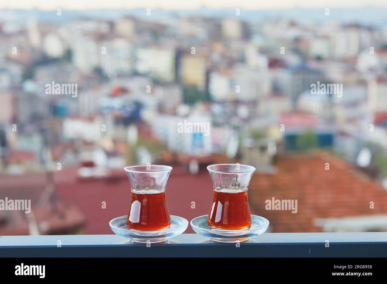 Due bicchieri turchi a forma di tulipano riempito di tè nero caldo con vista sui tetti del distretto di Uskudar sul lato asiatico di Istanbul, Turchia Foto Stock